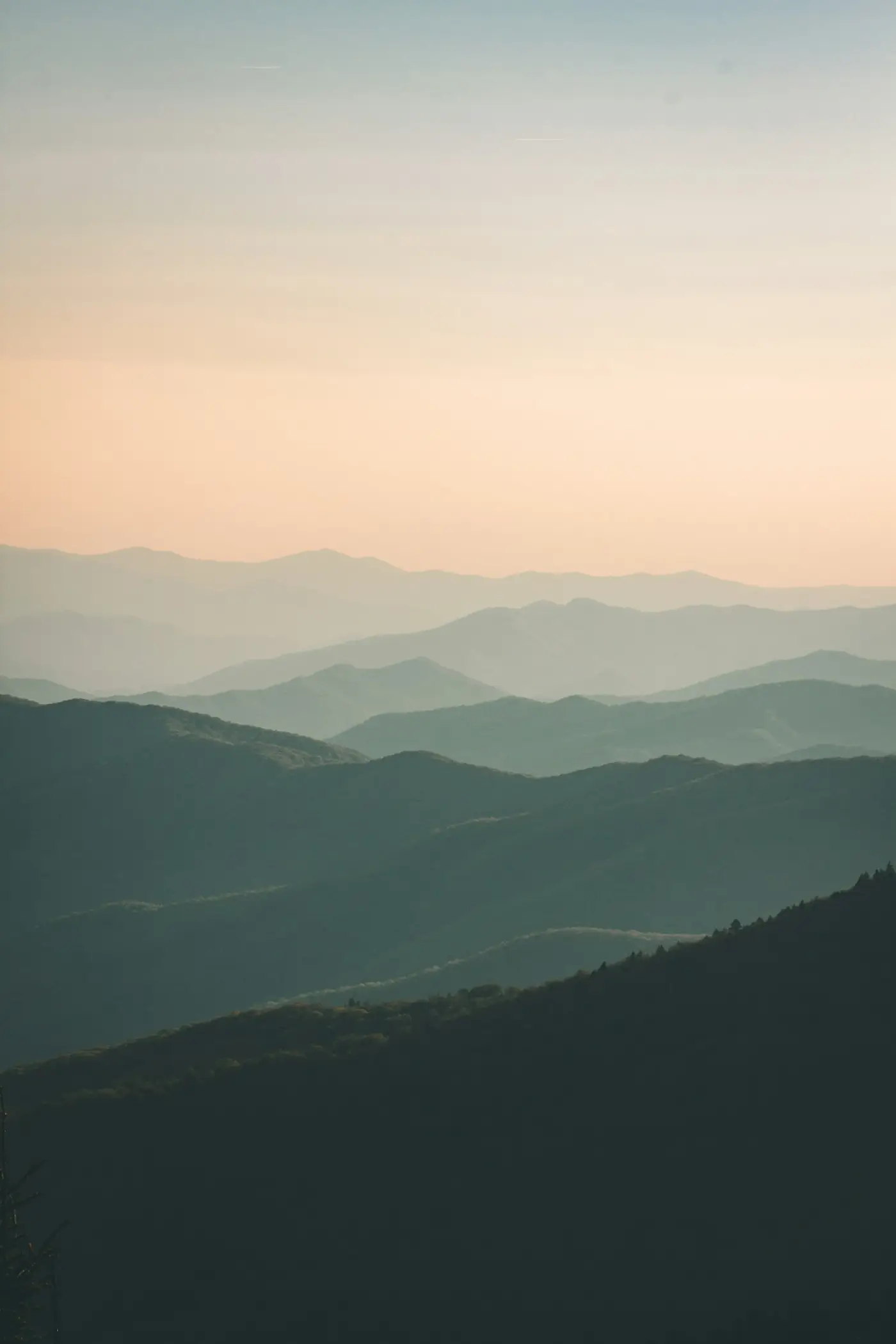 Soft hazy layers of hills fading into a pale sky