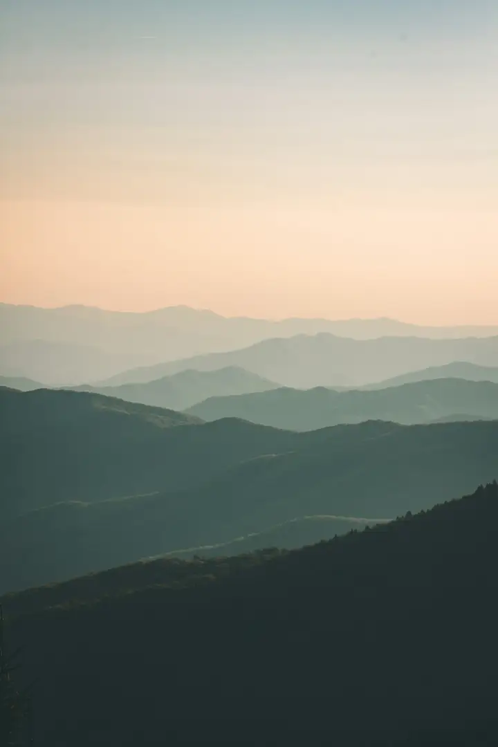 Soft hazy layers of hills fading into a pale sky